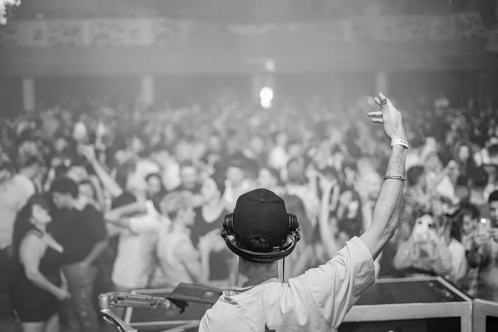 DJ spelar för en fullsatt publik, i svartvitt